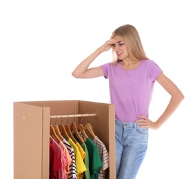 Young emotional woman near wardrobe box on white background