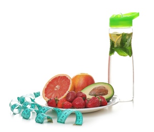 Photo of Plate with different tasty fruits, measuring tape and bottle of water on white background. Healthy diet