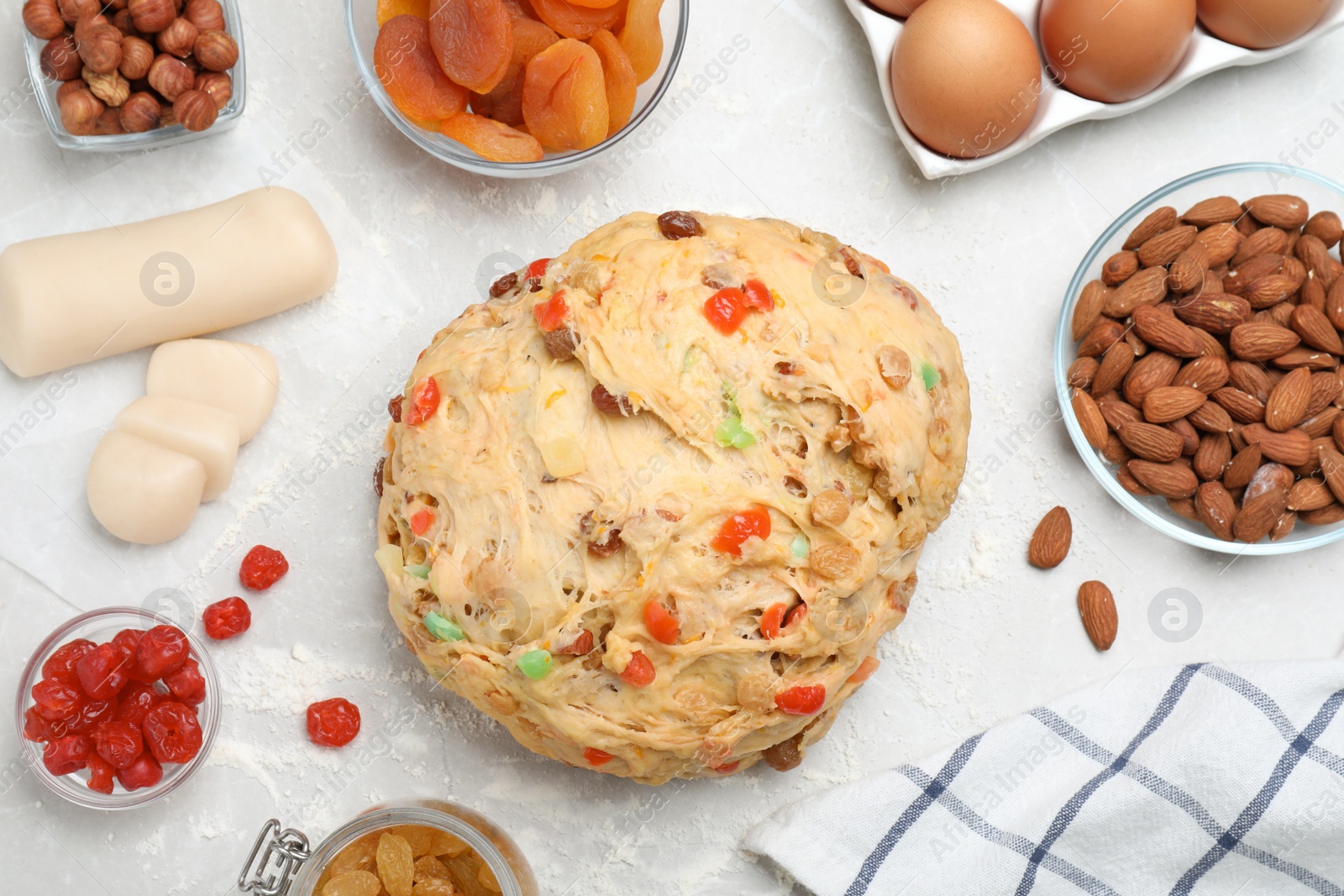 Photo of Raw dough with candied fruits and nuts for Stollen on white table, flat lay. Baking traditional German Christmas bread