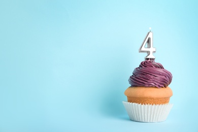 Photo of Birthday cupcake with number four candle on blue background, space for text