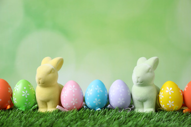 Easter bunnies and painted eggs on green grass