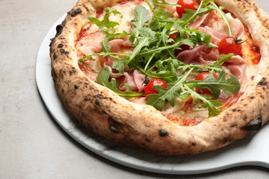 Photo of Tasty pizza with meat and arugula on grey table, closeup