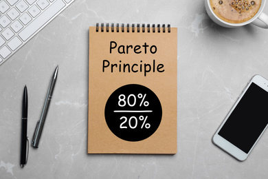 Pareto principle concept. Notebook with 80/20 rule representation on marble table, flat lay