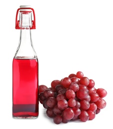 Photo of Bottle with wine vinegar and fresh grapes on white background