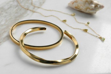 Photo of Elegant bracelets and necklace on white table, closeup