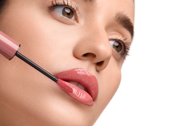 Photo of Woman applying lip gloss on white background