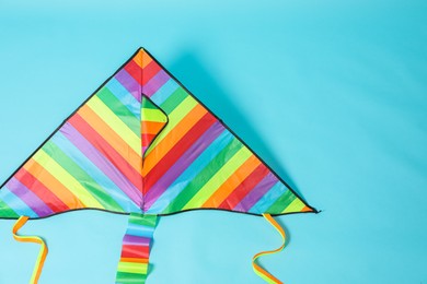 Photo of Bright rainbow kite on light blue background, top view