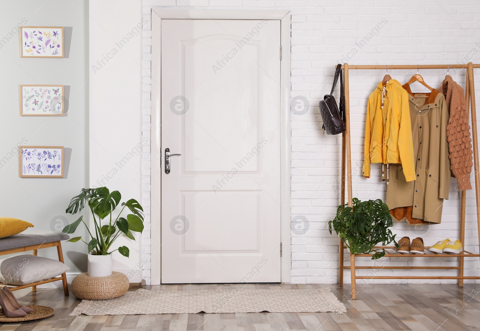 Photo of Hallway interior with stylish furniture, clothes and plants