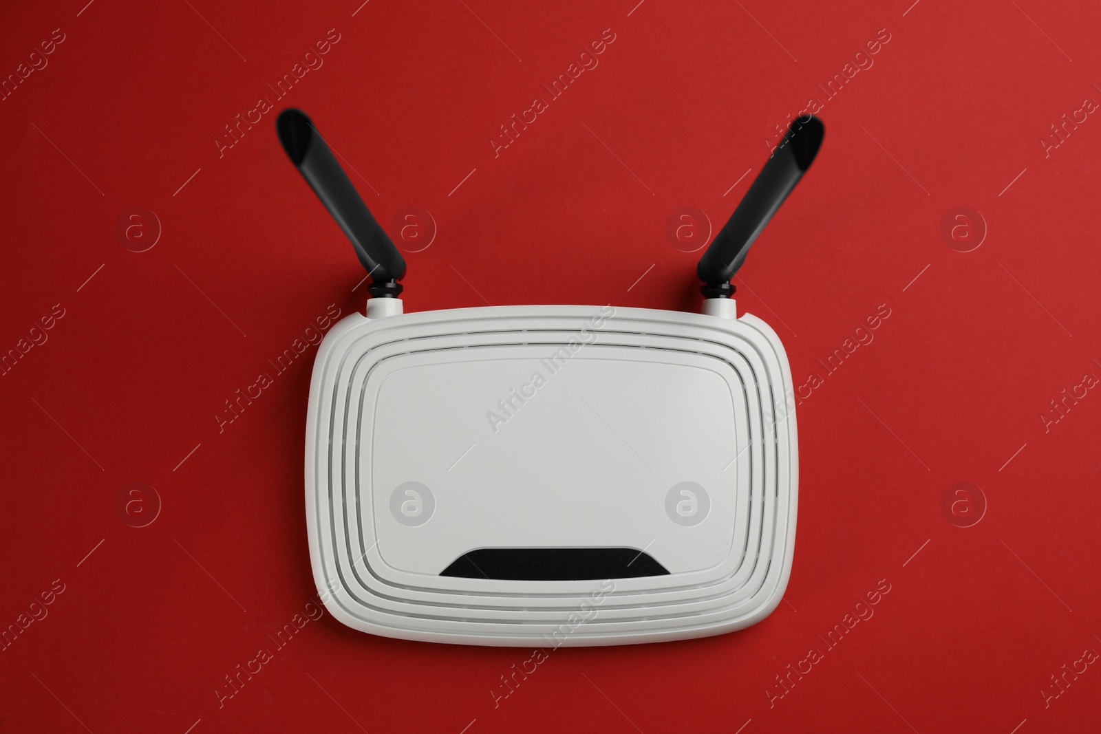 Photo of Modern Wi-Fi router on red background, top view