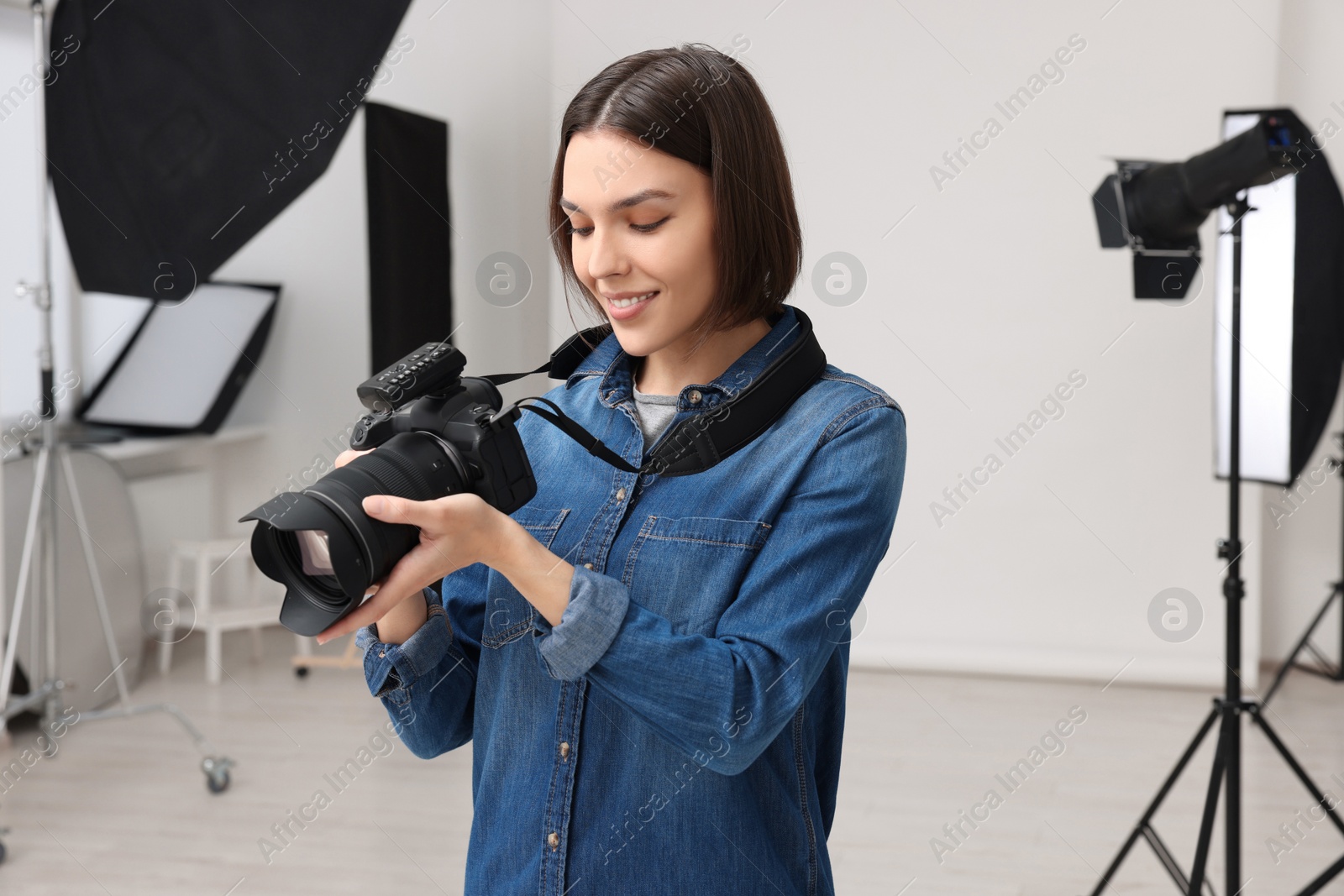 Photo of Professional photographer with camera in modern photo studio