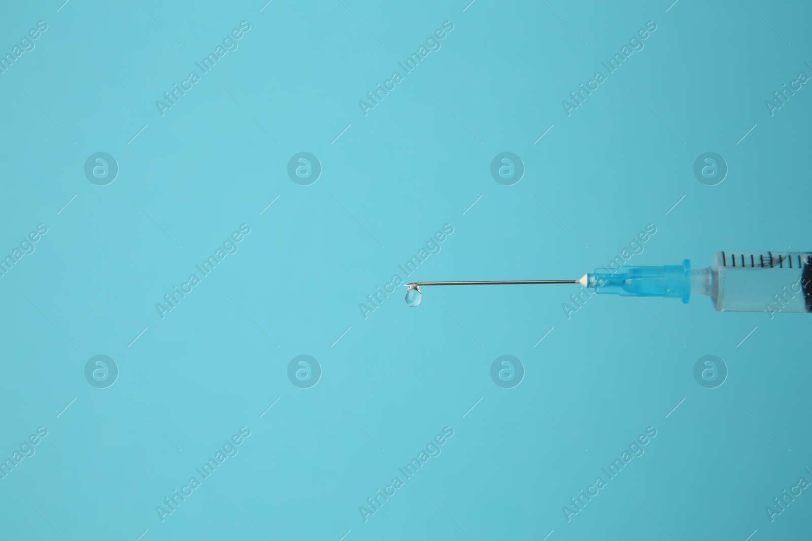 Medical syringe on light blue background, closeup. Space for text Photo of Medical syringe on light blue background, closeup. Space for text