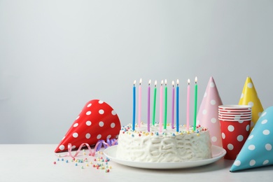 Delicious birthday cake with burning candles on table