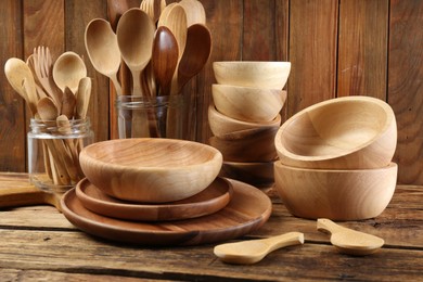 Many different wooden dishware and utensils on table