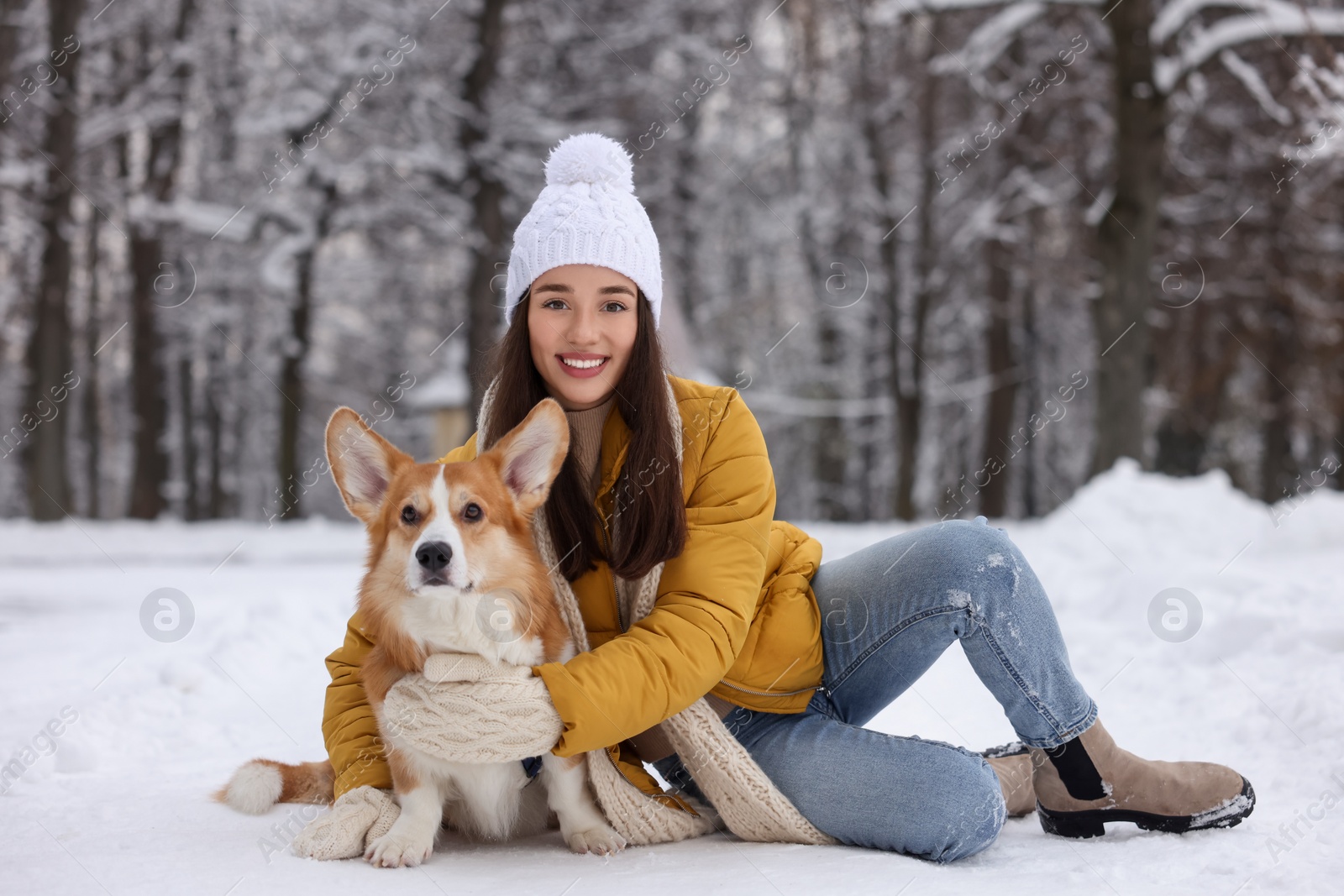 Photo of Woman with adorable Pembroke Welsh Corgi dog in snowy park