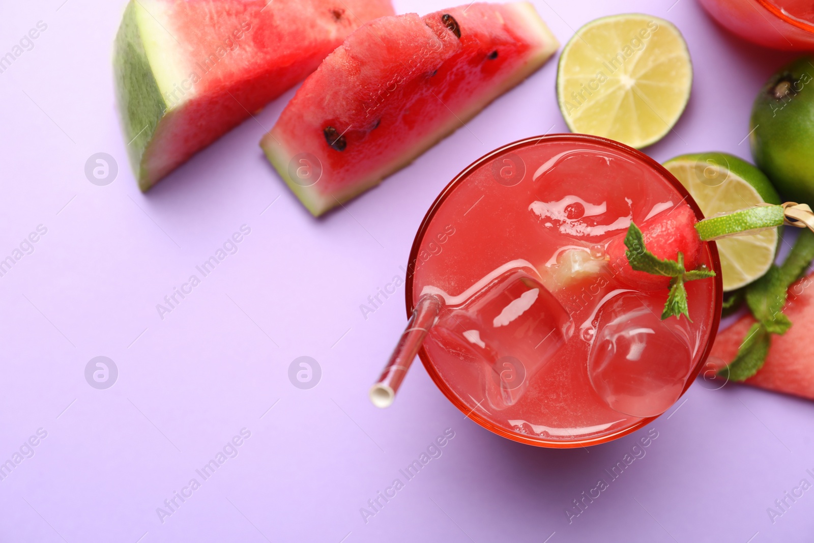 Photo of Tasty watermelon drink on violet background, flat lay. Space for text