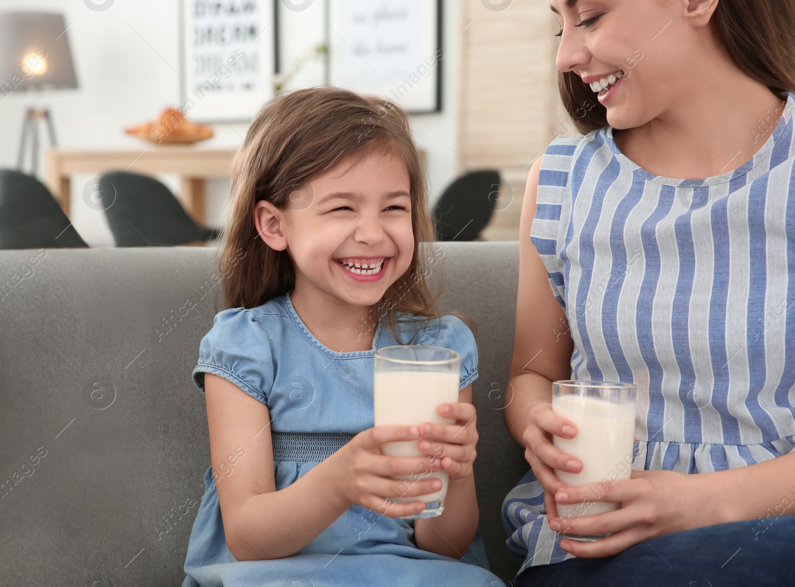 Photo of Happy family with glasses of milk in living room