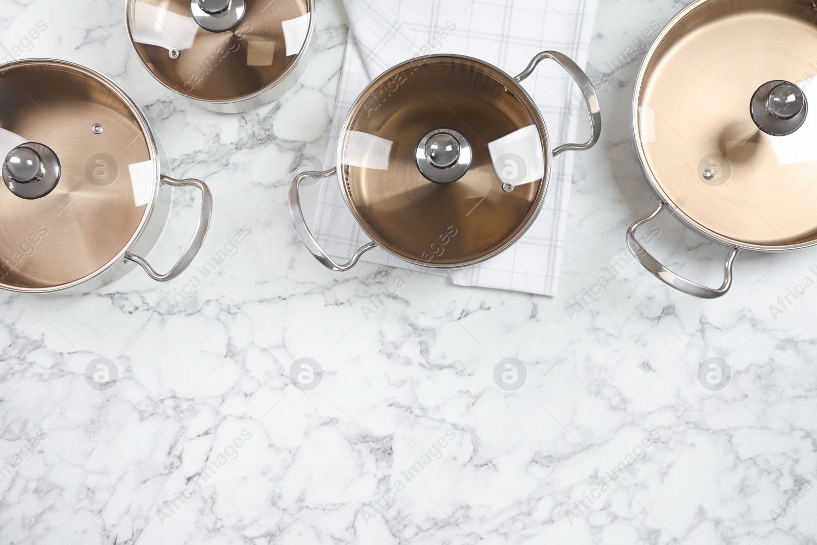 Photo of New cookware set on white marble table, flat lay. Space for text