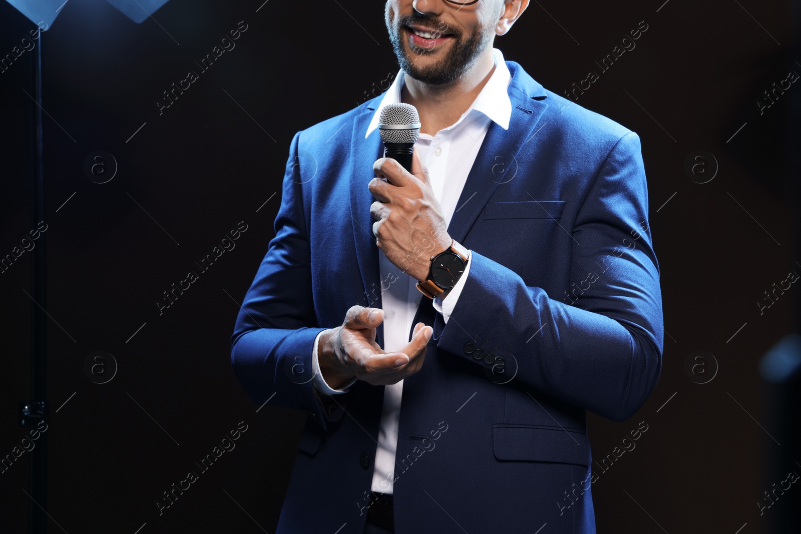 Photo of Motivational speaker with microphone performing on stage, closeup