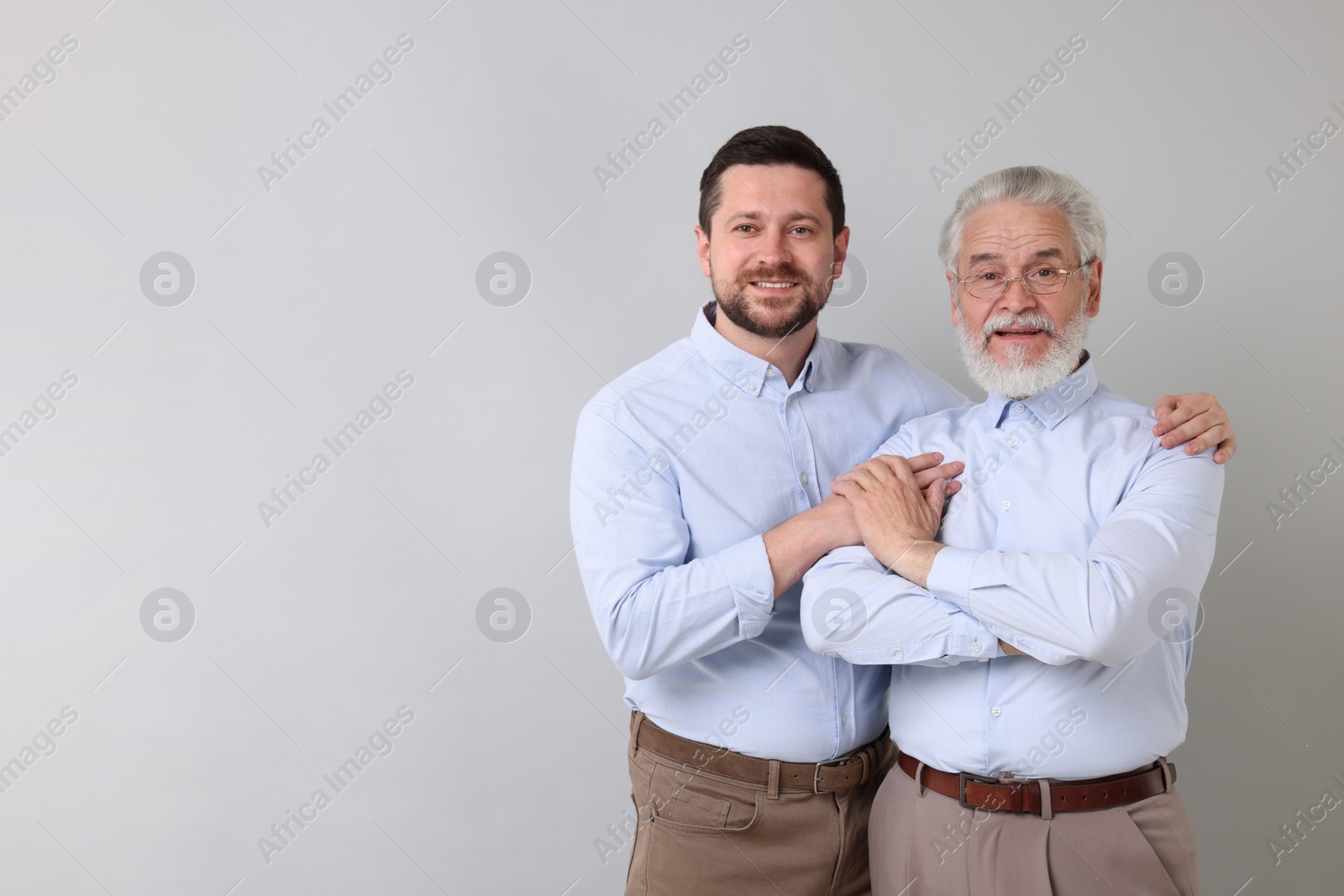 Photo of Happy son and his dad on gray background, space for text