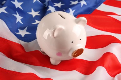 Photo of White piggy bank on American flag, closeup