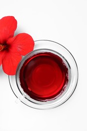 Photo of Delicious hibiscus tea and beautiful flower on white background, flat lay
