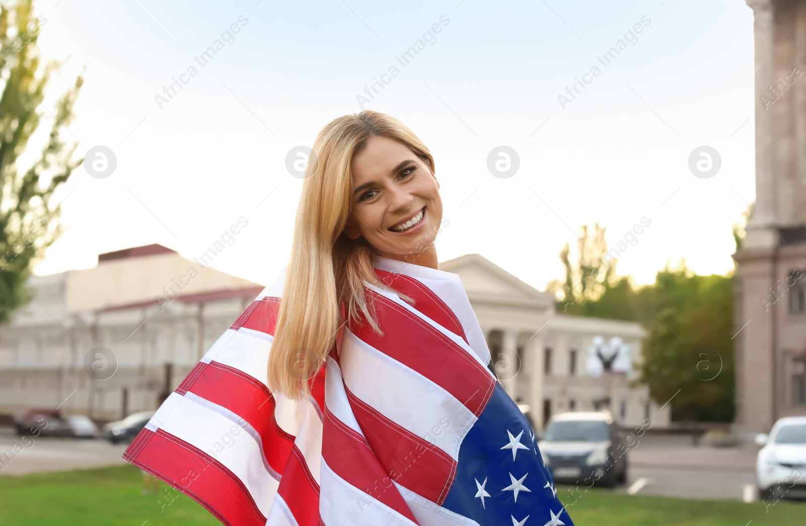 Photo of Woman with American flag on city street