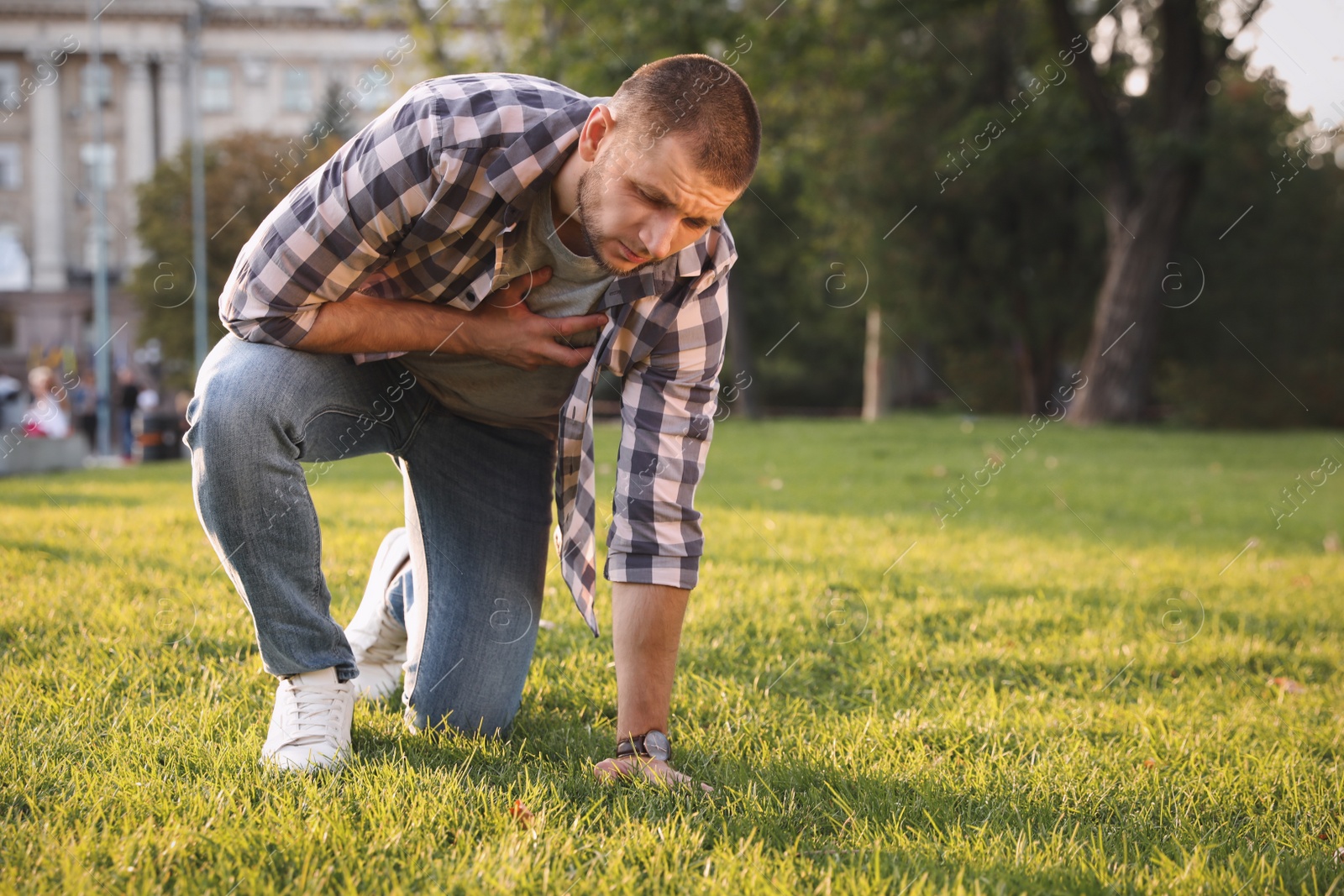 Photo of Man having heart attack on green grass in park
