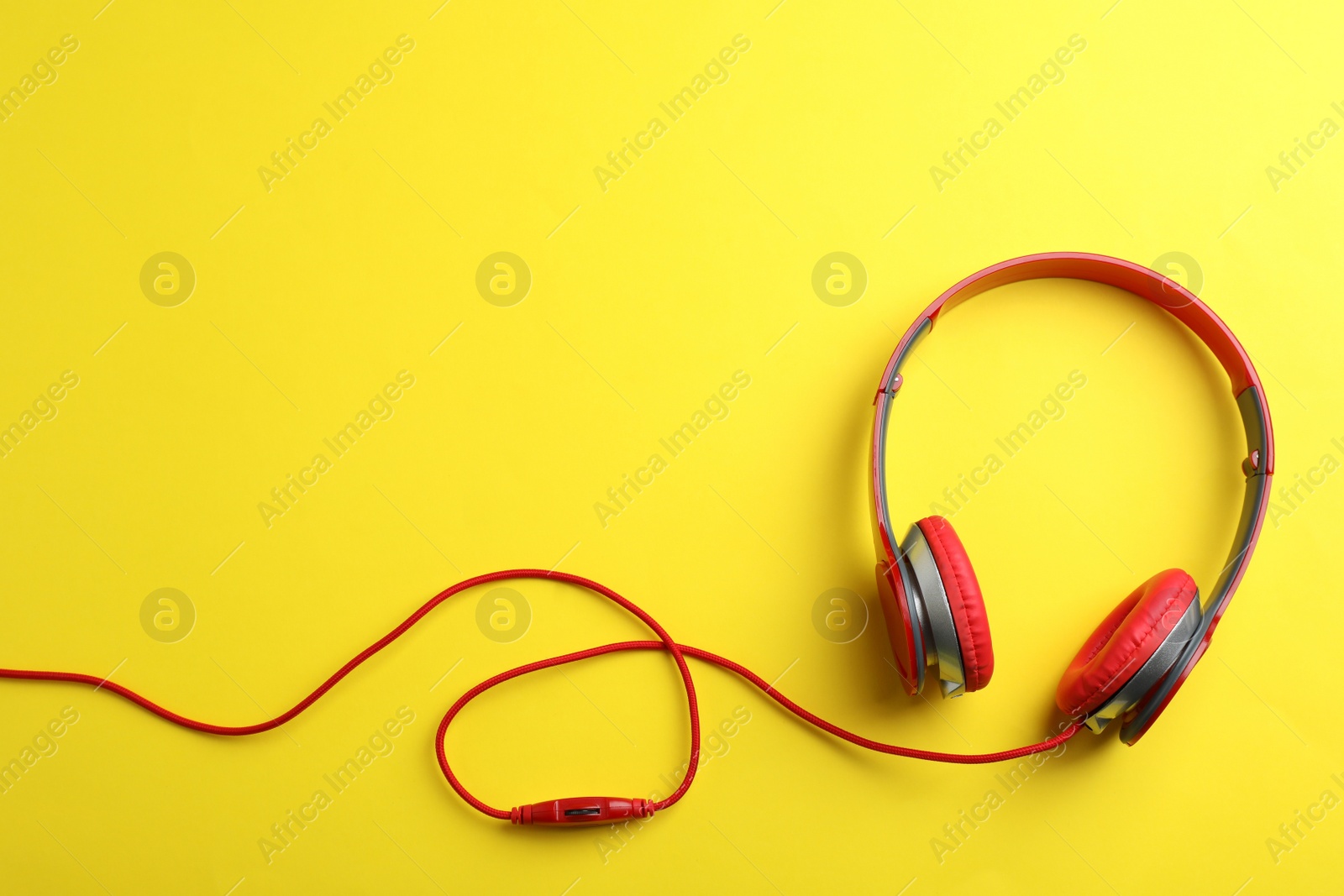 Photo of Stylish headphones on color background, top view. Space for text