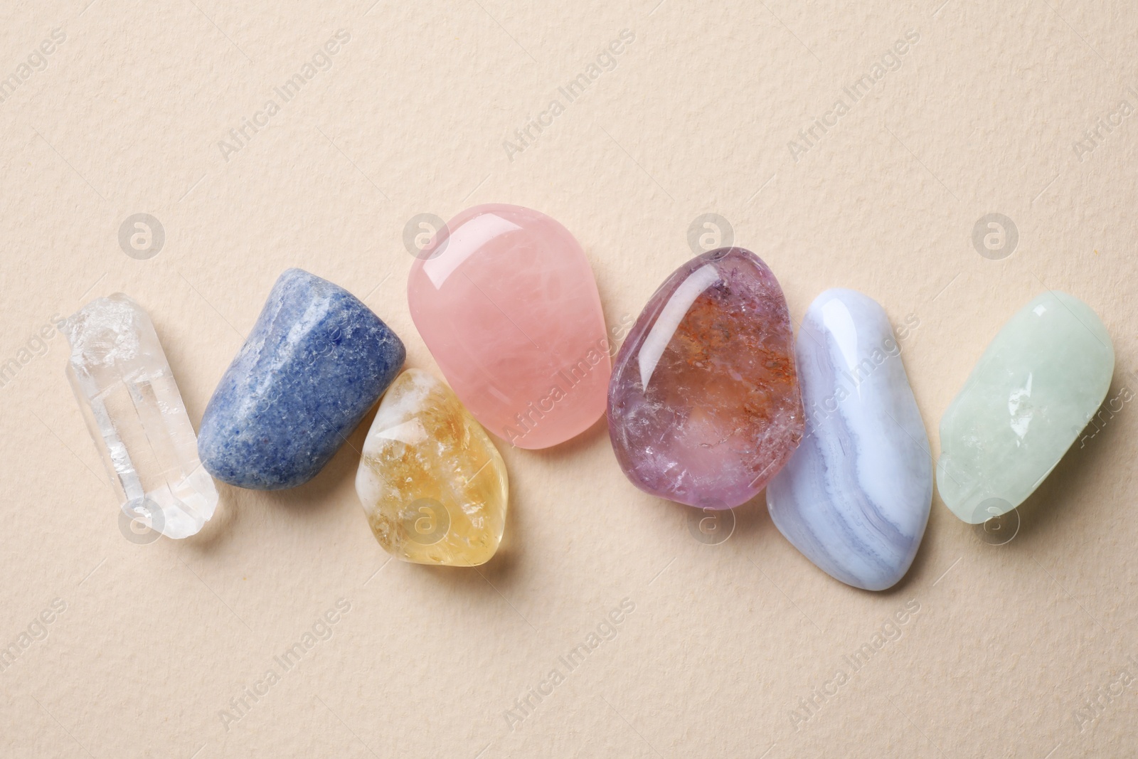 Photo of Beautiful gemstones on beige table, flat lay. Healing crystals