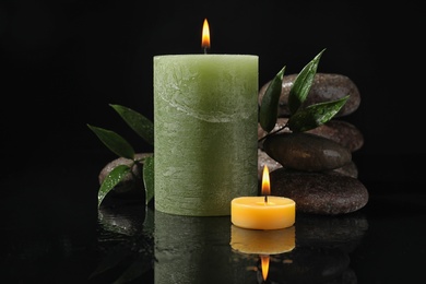 Photo of Composition with candles and spa stones on black background