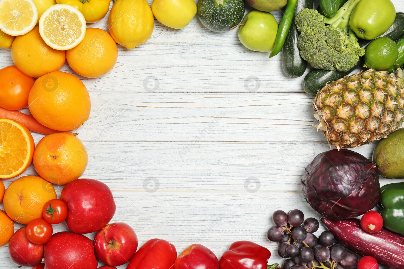 Photo of Rainbow frame made of fresh fruits and vegetables on wooden background