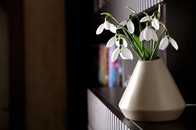 Photo of Vase with beautiful snowdrops on wooden table indoors, space for text