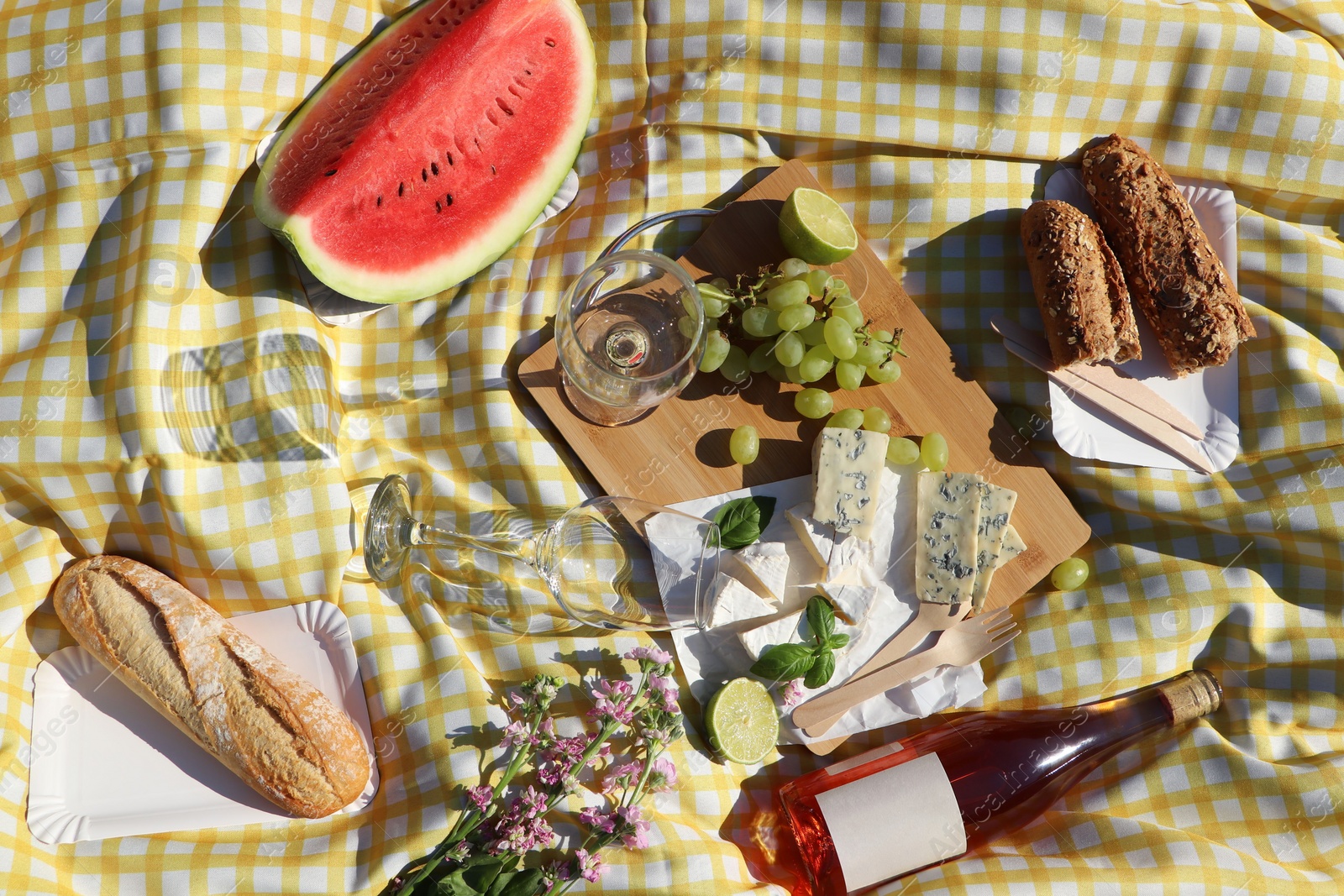 Photo of Delicious food and wine on picnic blanket, flat lay