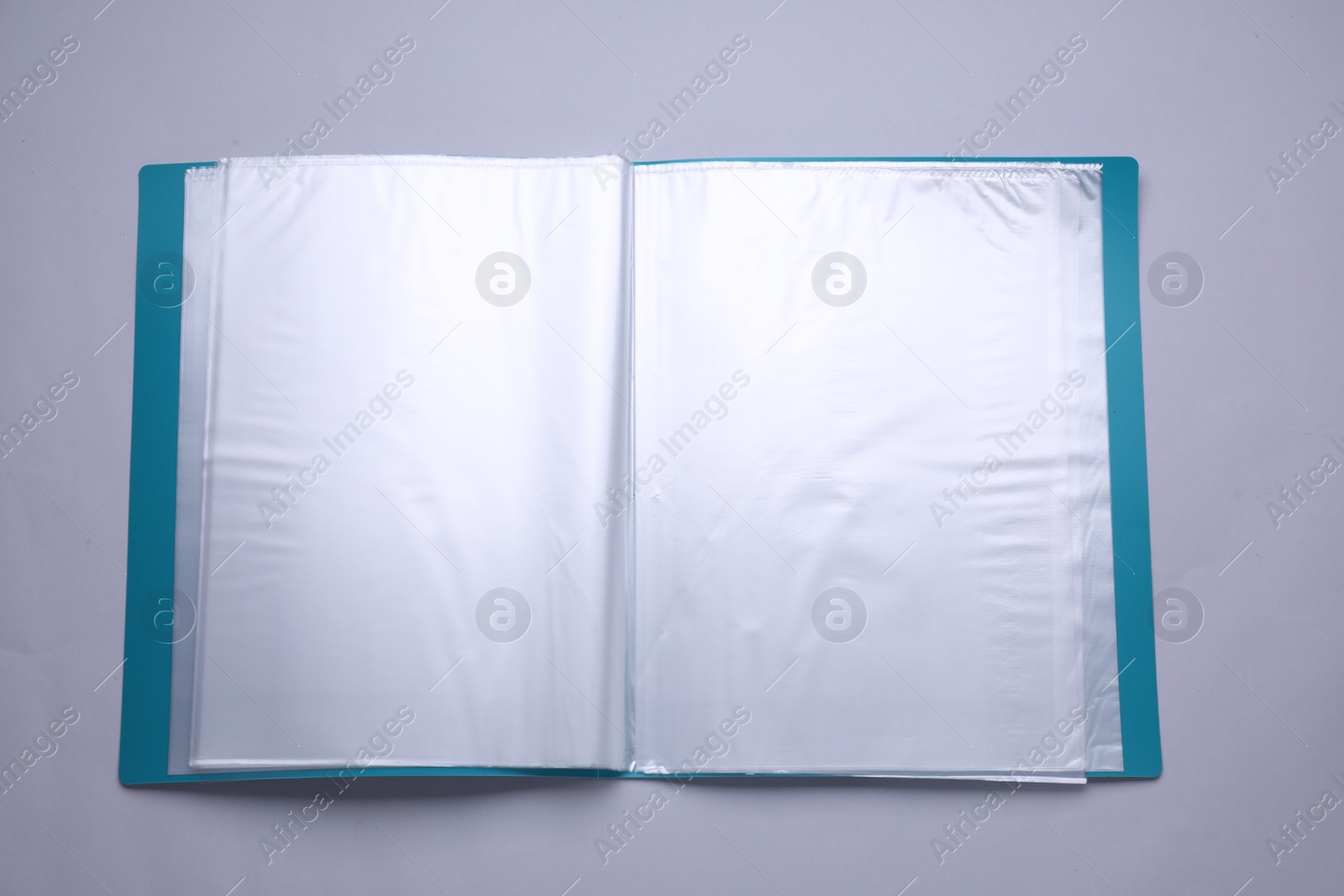 Photo of File folder with punched pockets and paper sheets on light grey background, top view