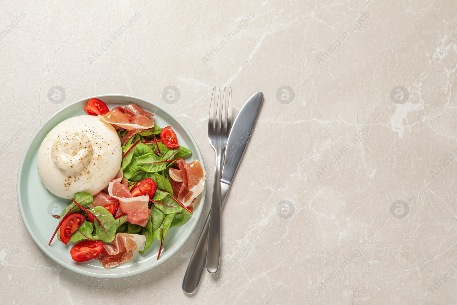 Photo of Delicious burrata salad served on light grey marble table, flat lay. Space for text