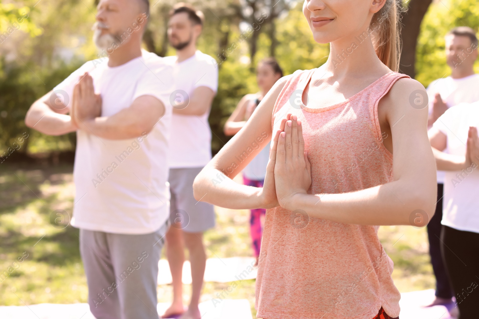 Photo of Group of people practicing yoga in park on sunny day