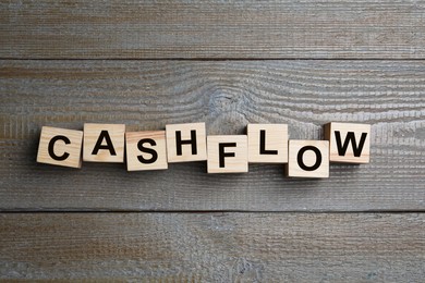 Image of Cubes with phrase Cash FLow on wooden background, flat lay