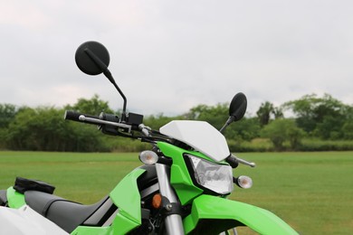 Photo of Stylish green cross motorcycle on grass outdoors