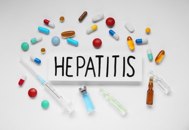 Photo of Word Hepatitis and medical supplies on white background, flat lay