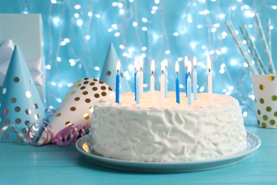 Photo of Delicious birthday cake with burning candles on table