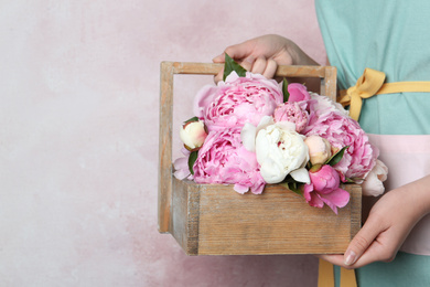 Photo of Woman with beautiful peonies on pink background, closeup