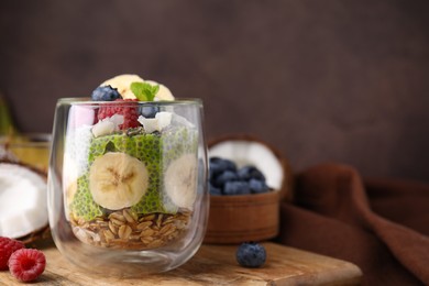 Tasty oatmeal with chia matcha pudding and fruits on wooden board, space for text. Healthy breakfast