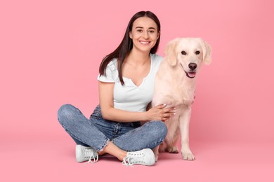 Photo of Happy woman with cute Labrador Retriever dog on pink background. Adorable pet