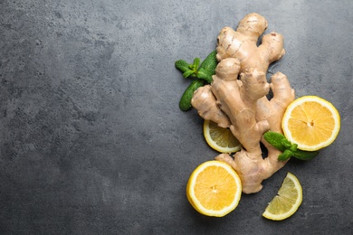 Photo of Fresh lemon, ginger and mint on grey table, flat lay. Space for text