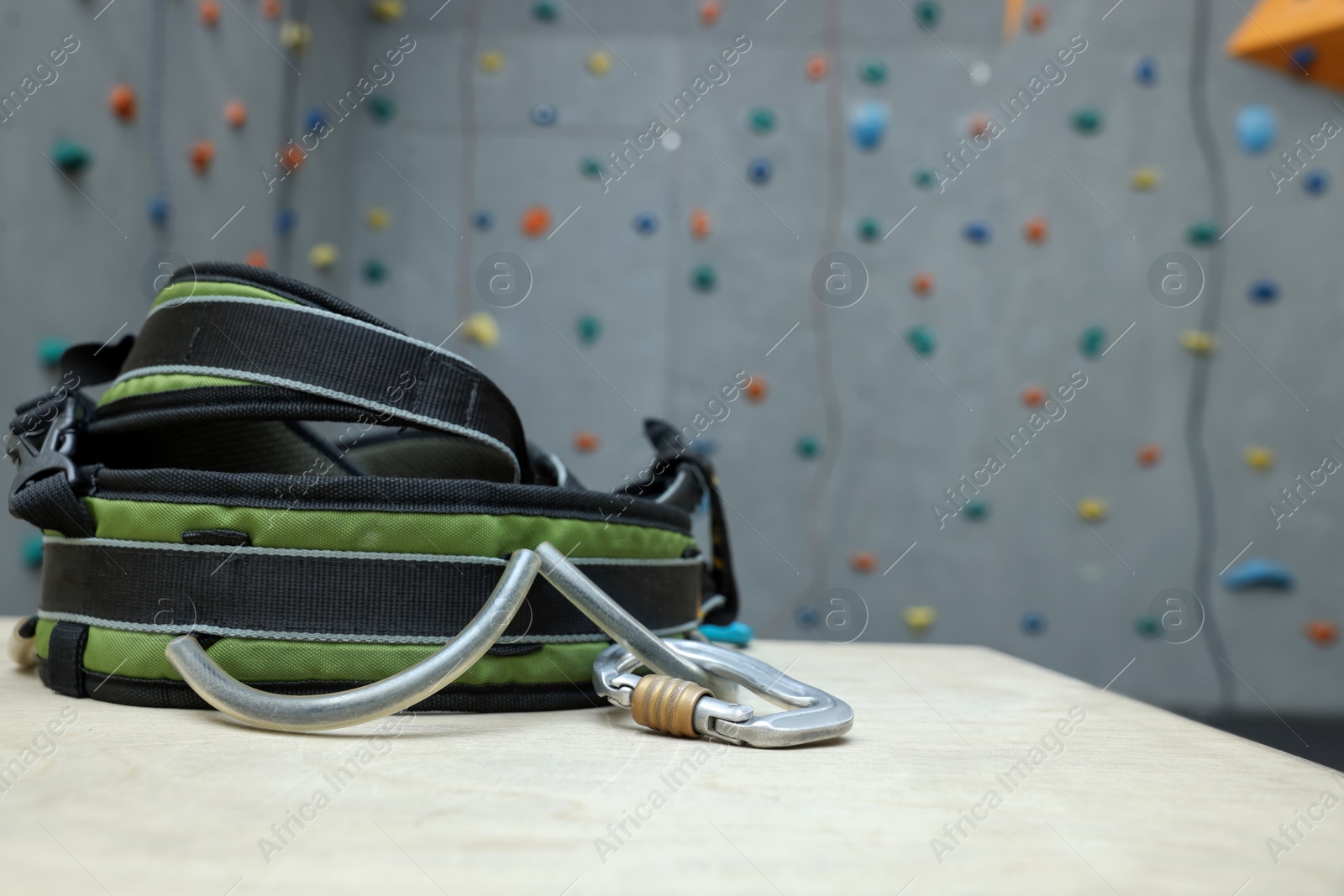 Photo of Climbing equipment on white table in gym. Space for text
