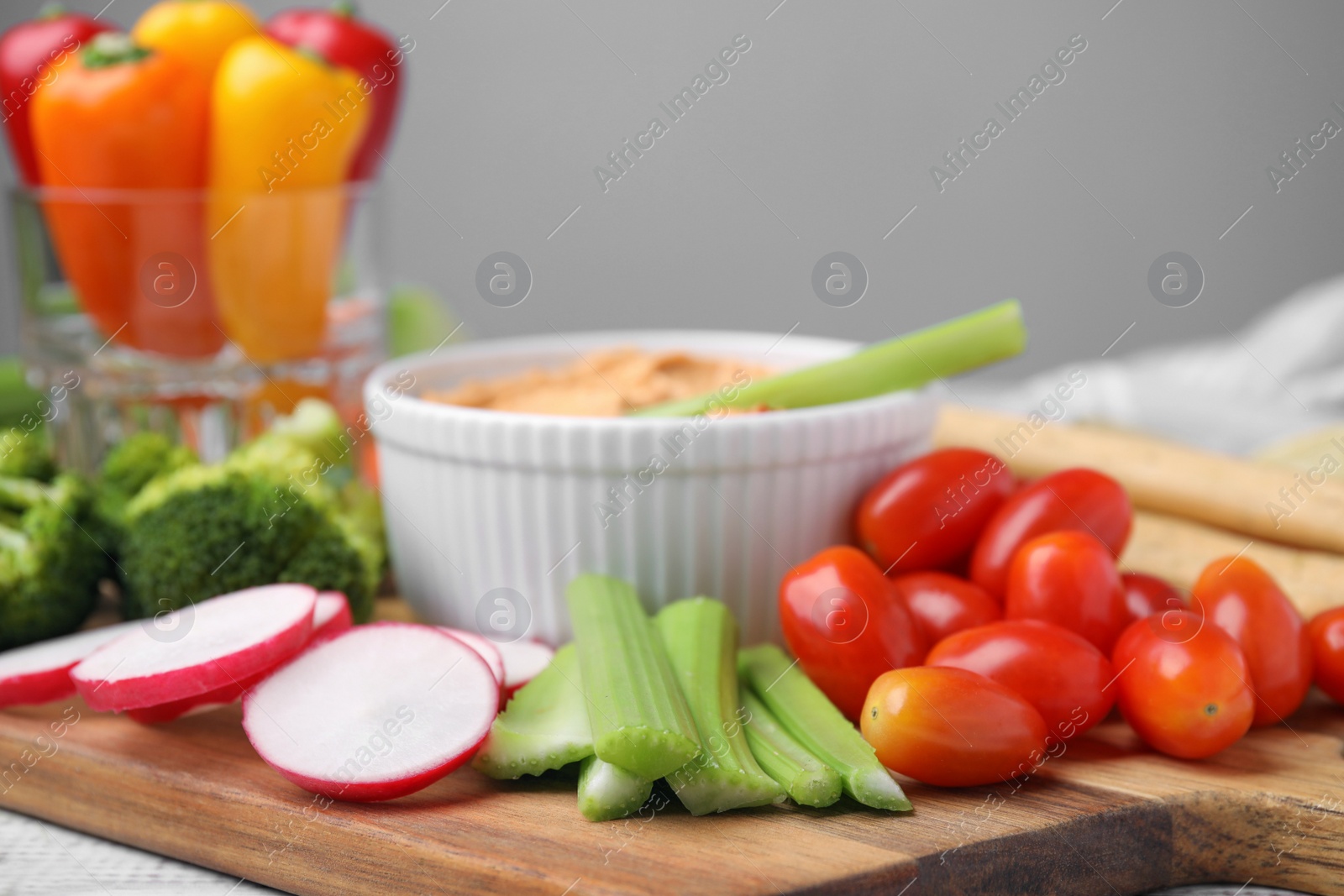 Photo of Board with delicious hummus and fresh vegetables, closeup