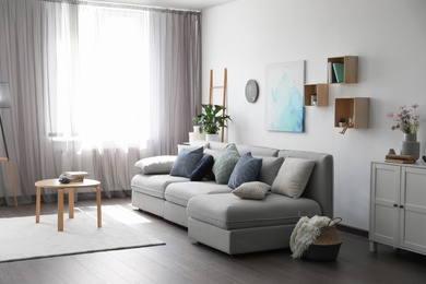 Photo of Elegant living room with comfortable sofa near window. Interior design