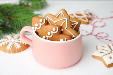 Photo of Cup with tasty homemade Christmas cookies on table