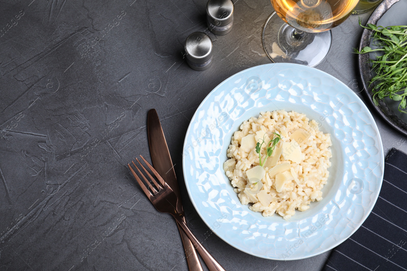 Photo of Delicious risotto with cheese on grey table, flat lay. Space for text