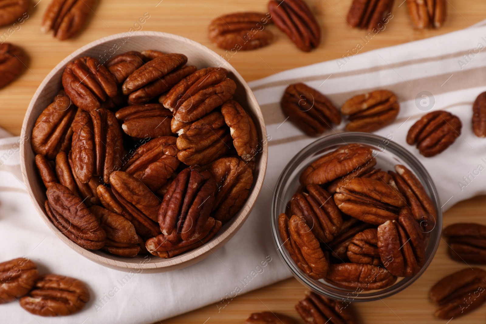 Photo of Tasty pecan nuts on wooden table, above view